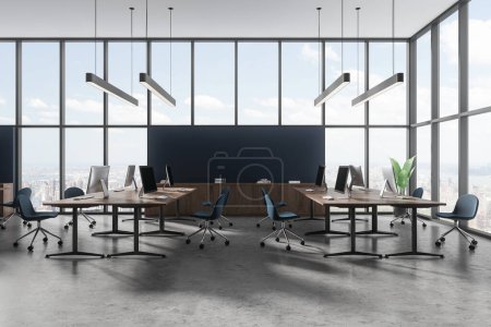 Photo for Interior of stylish open space office with blue walls, concrete floor, massive computer desks with blue chairs and panoramic windows with cityscape. 3d rendering - Royalty Free Image