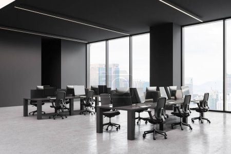 Photo for Dark coworking interior with pc computers and desk in row, side view concrete floor. Stylish coworking corner with panoramic window on Kuala Lumpur. 3D rendering - Royalty Free Image