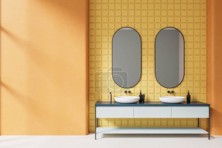 Téléchargez les photos : Intérieur de salle de bain moderne avec des murs carrelés orange et jaune, sol en béton et confortable double lavabo debout sur le comptoir blanc et bleu avec deux miroirs ovales. Rendu 3d - en image libre de droit