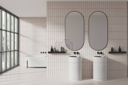 Foto de Interior de baño moderno con paredes de baldosas blancas, suelo de piedra, cómodo lavabo doble blanco con dos espejos ovalados y acogedora bañera blanca de pie cerca de una gran ventana. renderizado 3d - Imagen libre de derechos