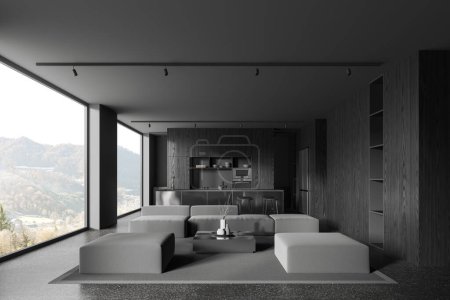 Foto de Interior de la elegante sala de estar con paredes de madera gris y oscura, acogedor sofá gris y sillones de pie cerca de la mesa de café cuadrado y cómoda cocina con isla en el fondo. renderizado 3d - Imagen libre de derechos