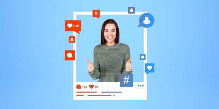 Photo for Portrait of smiling young European woman showing thumb up sign in photo frame with social media icons over blue background. Concept of social media and blogger influencer - Royalty Free Image