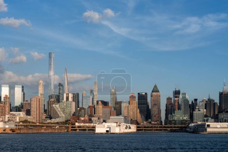 Téléchargez les photos : New York Manhattan gratte-ciel et Hudson River avec nuages, front de mer et immeubles de bureaux, centre financier du commerce mondial. NYC midtown buildings skyline under blue sky - en image libre de droit