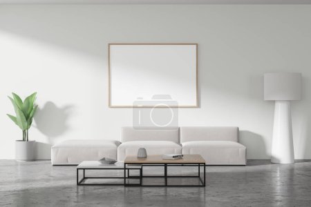 Foto de Interior de la moderna sala de estar con paredes blancas, suelo de hormigón, cómodo sofá gris de pie cerca de dos mesas de café cuadradas y la maqueta horizontal de póster. renderizado 3d - Imagen libre de derechos