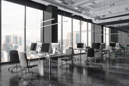 Foto de Interior oscuro de la oficina con zona de coworking, ordenadores PC en el escritorio compartido en fila, vista lateral piso de granito gris. Sala de reuniones de cristal y ventana panorámica de los rascacielos Kuala Lumpur. Renderizado 3D - Imagen libre de derechos