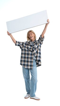 Téléchargez les photos : Femme souriante debout sur toute la longueur, tenant un panneau blanc maquette dans les mains sur fond blanc isolé. Concept de recommandation, d'annonce et de signature - en image libre de droit