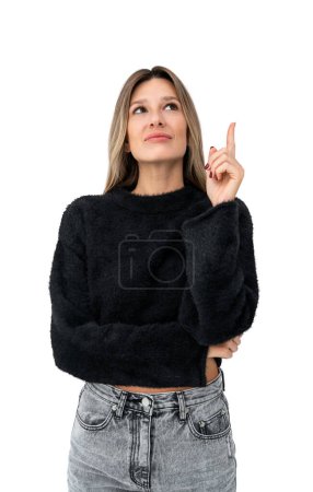Téléchargez les photos : Portrait de jeune femme réfléchie portant des vêtements décontractés et debout avec index levé isolé sur fond blanc. Concept de planification et idée brillante - en image libre de droit