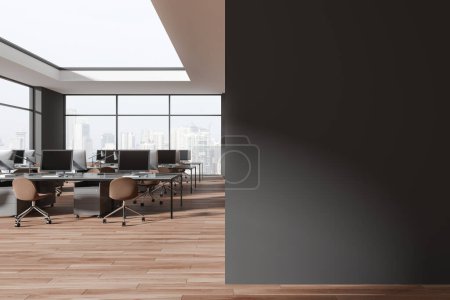 Foto de Interior oscuro de la oficina con el escritorio de la PC en la fila, mesa compartida en el piso de madera. Elegante espacio de coworking y ventana panorámica de los rascacielos de Singapur. Mockup copia la partición de pared de espacio. Renderizado 3D - Imagen libre de derechos