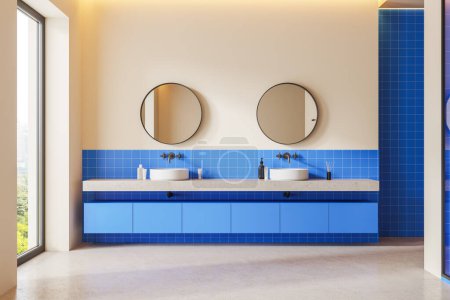 Foto de Interior de baño en casa beige y azul con doble lavabo y espejo redondo, diseño de azulejos y piso de hormigón ligero. Ventana panorámica con vista a la ciudad. Renderizado 3D - Imagen libre de derechos