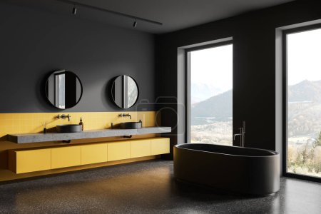 Téléchargez les photos : Intérieur de la salle de bain de l'hôtel sombre et jaune avec double lavabo et baignoire, vue latérale sol en granit gris. Coin baignade près de la fenêtre panoramique sur la campagne. rendu 3D - en image libre de droit
