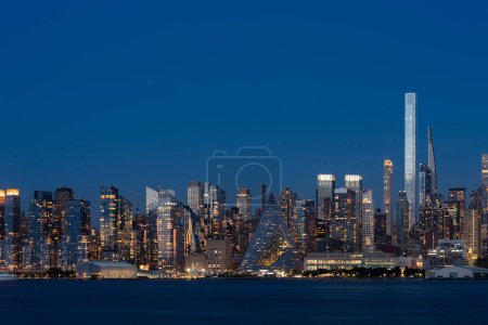 Foto de Rascacielos de Nueva York y río Hudson por la noche, frente al mar y edificios financieros corporativos, centro de comercio de negocios. horizonte de la oficina de Manhattan con luces brillantes - Imagen libre de derechos