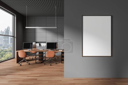 Photo for Grey and wooden coworking interior with chairs, table with pc monitors in row and shelf. Panoramic window on New York skyscrapers. Mock up canvas poster on partition. 3D rendering - Royalty Free Image