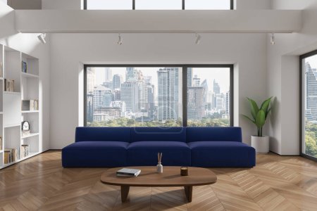 Foto de Interior de la moderna sala de estar con paredes blancas, suelo de madera, cómodo sofá azul de pie cerca de la mesa de centro de madera y librería blanca. renderizado 3d - Imagen libre de derechos