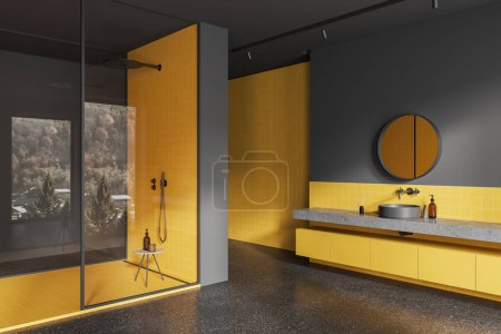Téléchargez les photos : Intérieur de salle de bain intérieure sombre et jaune avec lavabo et douche, cloison en verre et tabouret avec accessoires. Vue en angle de l'espace de baignade avec fenêtre en réflexion. rendu 3D - en image libre de droit