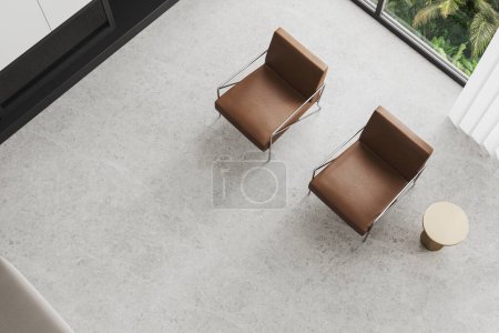 Téléchargez les photos : Vue de dessus de la maison élégante lieu de détente intérieur avec deux fauteuils en cuir brun, cheminée et plancher en béton clair. Fenêtre panoramique sur les tropiques. rendu 3D - en image libre de droit