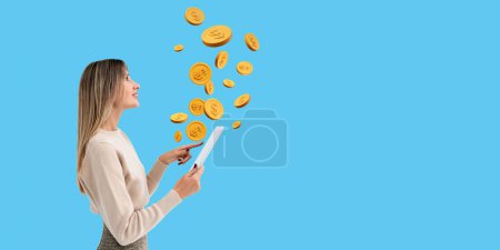 Photo for Young beautiful woman using tablet looking up at falling gold dollar coins, empty blue background. Copy space empty wall. Concept of money transaction, transfer, income and cashback - Royalty Free Image