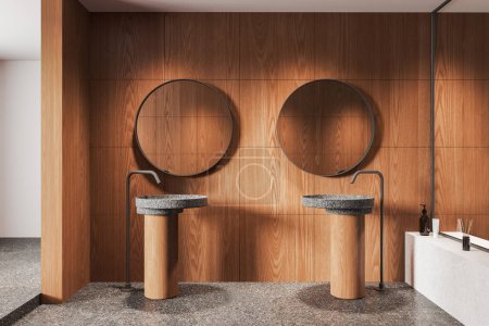 Téléchargez les photos : Intérieur luxueux de la salle de bain de l'hôtel en bois avec deux éviers séparés et mélangeur monté, miroirs ronds en rangée. Étagère minimaliste avec accessoires sur sol en granit gris. rendu 3D - en image libre de droit