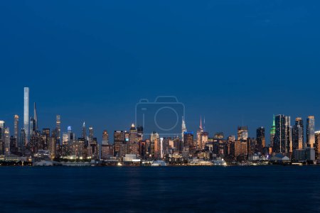 Foto de Rascacielos de Nueva York y el río Hudson por la noche, frente al mar y edificios de oficinas, centro financiero de negocios. Manhattan edificios del horizonte del centro con luces - Imagen libre de derechos