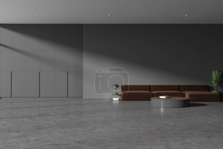 Photo for Interior of stylish living room with gray walls, concrete floor, cozy brown couch standing near round coffee table and big gray wardrobe. 3d rendering - Royalty Free Image