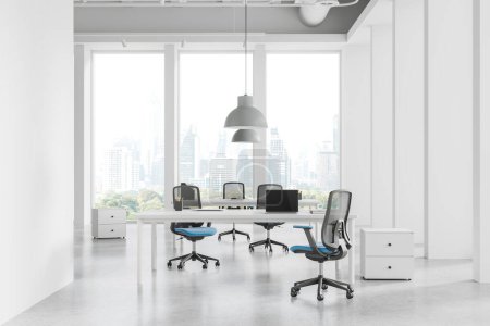 Photo for Elegant workplace interior with armchairs and table in row, drawer on light concrete floor. Business coworking room or library with laptop, panoramic window on Bangkok skyscrapers. 3D rendering - Royalty Free Image