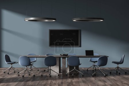 Photo for Dark blue office meeting interior with chairs and board, tv display on wall. Minimalist negotiation space with laptop computer on table and two led round pendant lamps. 3D rendering - Royalty Free Image
