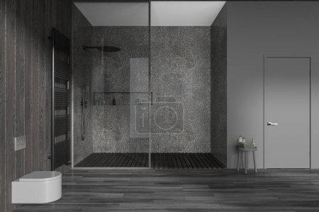 Téléchargez les photos : Intérieur de salle de bain moderne sombre avec douche en verre et toilettes suspendues murales, table d'appoint avec accessoires et porte-serviettes. Salle de bain dans un appartement de luxe avec porte. rendu 3D - en image libre de droit