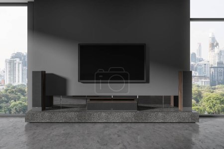 Foto de Interior de la sala de estar en casa oscura con pantalla de tv con sistema de sonido, consola de cine en casa en piso de hormigón gris. Ventana panorámica de los rascacielos de Bangkok. Renderizado 3D - Imagen libre de derechos