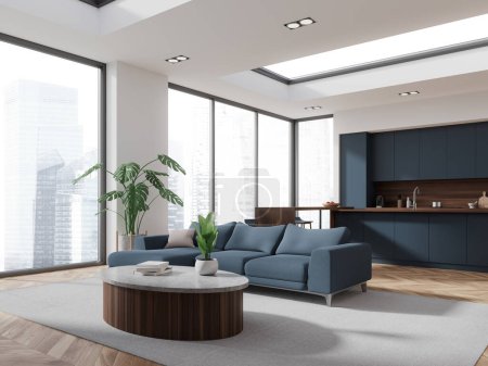 Foto de Interior de la moderna sala de estar con paredes blancas, suelo de madera, acogedor sofá azul y mesa de centro y cocina cómoda con armarios azules en el fondo. renderizado 3d - Imagen libre de derechos