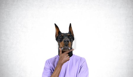 Foto de Retrato de un joven reflexivo con cabeza de perro de pie con la mano en la barbilla sobre el fondo de la pared de hormigón. Concepto de planificación e ideas brillantes - Imagen libre de derechos
