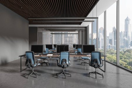 Téléchargez les photos : Intérieur du bureau moderne à aire ouverte avec murs gris, sol en béton et rangées de bureaux d'ordinateur avec chaises bleues. Rendu 3d - en image libre de droit