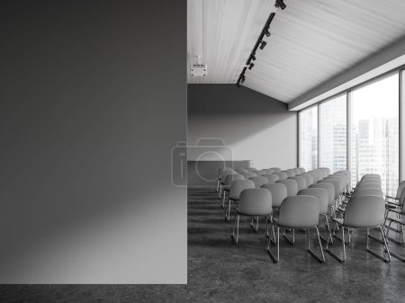 Téléchargez les photos : Intérieur de salle de conférence élégante avec murs gris, sol en béton, rangées de chaises grises et table de conférenciers gris. Copier le mur d'espace sur la gauche. Rendu 3d - en image libre de droit