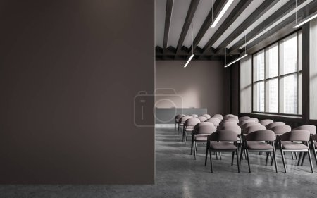 Téléchargez les photos : Intérieur d'une élégante salle de conférence avec murs bruns, sol en béton, rangées de chaises étudiantes brunes et table de conférenciers en bois foncé. Copier le mur d'espace sur la gauche. Rendu 3d - en image libre de droit