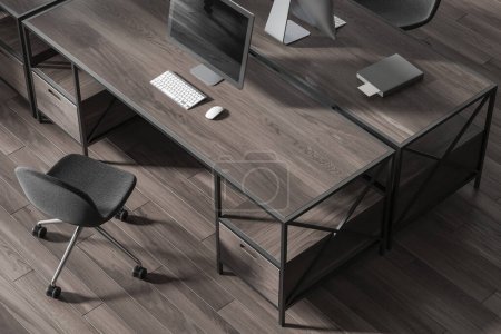 Téléchargez les photos : Vue de dessus du bureau élégant à aire ouverte avec plancher en bois et bureaux en bois sombre avec des chaises grises. Rendu 3d - en image libre de droit