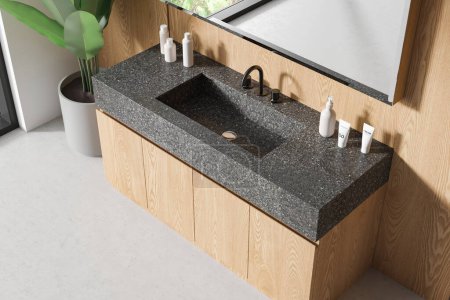 Photo for Top view of bathroom interior sink, wooden vanity and granite countertop. Stylish washbasin with mirror and plant in the corner, light concrete floor. 3D rendering - Royalty Free Image