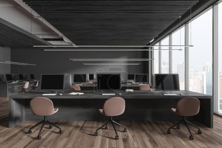 Téléchargez les photos : Dark office interior with seats and pc desktop, shared table on hardwood floor. Office business workspace and panoramic window on Singapore skyscrapers. 3D rendering - en image libre de droit