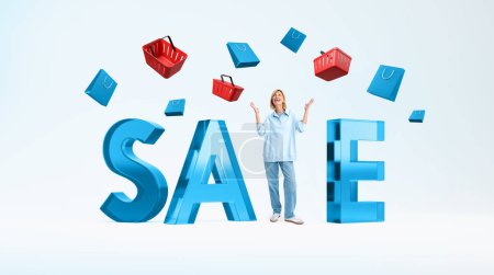 Téléchargez les photos : Surprised woman full length with raised hands, standing near glass large sale word, falling shopping baskets with bags. Concept of good offer, discount and commercial - en image libre de droit