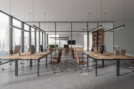 Photo for Stylish coworking room with pc computers on desk, glass partition and shelf with decoration. Panoramic window on Kuala Lumpur skyscrapers. 3D rendering - Royalty Free Image