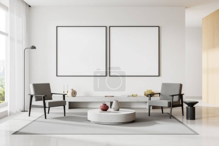 Foto de Interior de la moderna sala de estar con paredes blancas, suelo de hormigón, dos cómodos sillones grises de pie cerca de la mesa de café redonda y dos carteles simulados cuadrados. renderizado 3d - Imagen libre de derechos