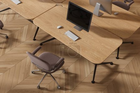Téléchargez les photos : Vue de dessus de l'intérieur de coworking avec des ordinateurs PC sur le bureau, chaises brunes sur plancher de bois franc. Lieu de travail de bureau en bois avec des meubles pour le travail d'équipe. rendu 3D - en image libre de droit