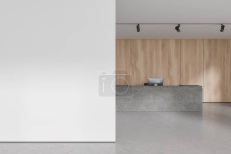 Téléchargez les photos : Intérieur du hall de bureau moderne avec murs blancs et en bois, sol en béton, long comptoir de réception gris avec ordinateur et mur d'espace de copie sur la gauche. Rendu 3d - en image libre de droit