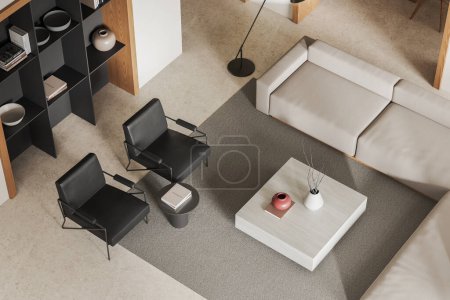 Téléchargez les photos : Vue de dessus de l'intérieur élégant et froid avec canapé et deux fauteuils en cuir, étagère et table basse avec décoration, tapis sur sol en béton beige. rendu 3D - en image libre de droit