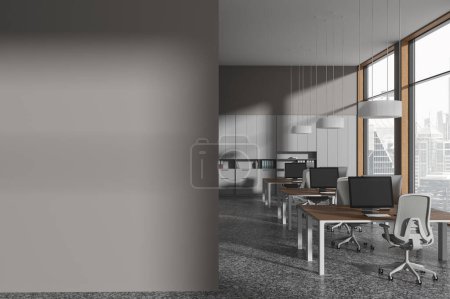 Téléchargez les photos : Intérieur d'un élégant bureau à aire ouverte avec murs gris, sol en béton, rangée de bureaux d'ordinateur et mur d'espace de copie sur la gauche. Rendu 3d - en image libre de droit