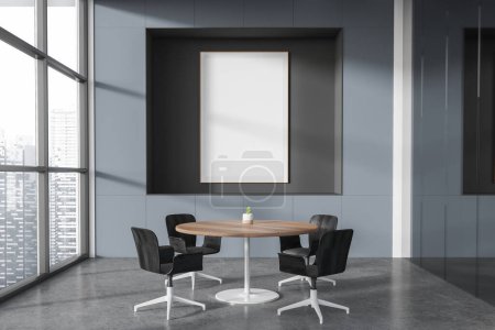 Foto de Interior de la elegante sala de reuniones de oficina con paredes grises, suelo de hormigón, mesa redonda con sillas negras y póster de maqueta vertical. renderizado 3d - Imagen libre de derechos