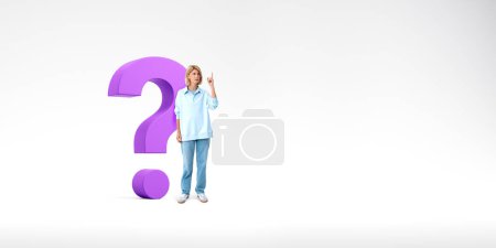Téléchargez les photos : Jeune femme européenne pointant vers le haut debout près de gros point d'interrogation violet sur fond d'espace de copie blanche. Concept de curiosité - en image libre de droit