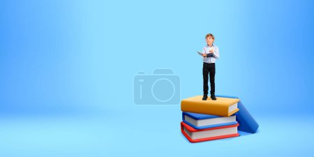 Photo for Child boy taking notes in notebook, empty copy space blue background. Inspired portrait looking up. Concept of education, knowledge, research and online learning - Royalty Free Image