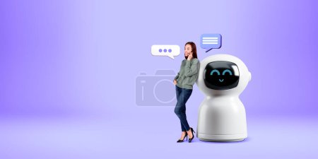 Téléchargez les photos : Femme souriante parlant au téléphone, debout sur toute la longueur près de dessin animé robot AI avec des bulles de parole sur l'espace de copie fond violet vide. Concept d'assistant virtuel et de communication bot - en image libre de droit