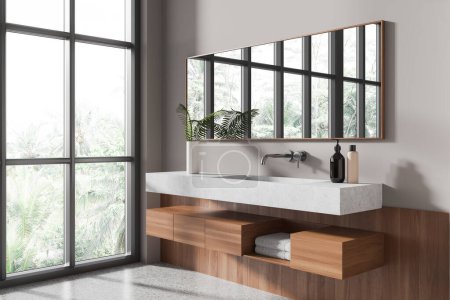Téléchargez les photos : Vue en angle de l'intérieur confortable de la salle de bain de l'hôtel avec lavabo et miroir, fenêtre panoramique sur les tropiques. Comptoir en pierre et vanité en bois avec serviette. rendu 3D - en image libre de droit