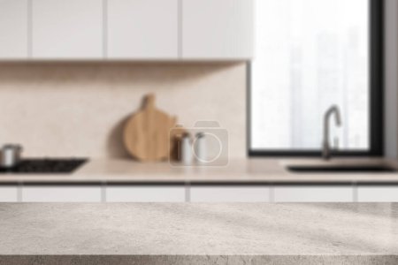 Foto de Mesa de exhibición de productos de piedra blanca ubicada en una elegante cocina borrosa con paredes beige, gabinetes blancos y ventana. renderizado 3d - Imagen libre de derechos
