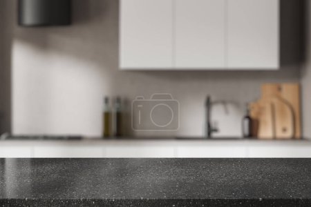 Foto de Mesa de exposición de productos de piedra oscura en la moderna cocina borrosa con paredes beige y armarios y armarios blancos. renderizado 3d - Imagen libre de derechos