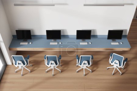 Foto de Vista superior del elegante interior de la oficina de coworking con paredes blancas, suelo de madera y mesa de ordenador larga con sillas azules. renderizado 3d - Imagen libre de derechos